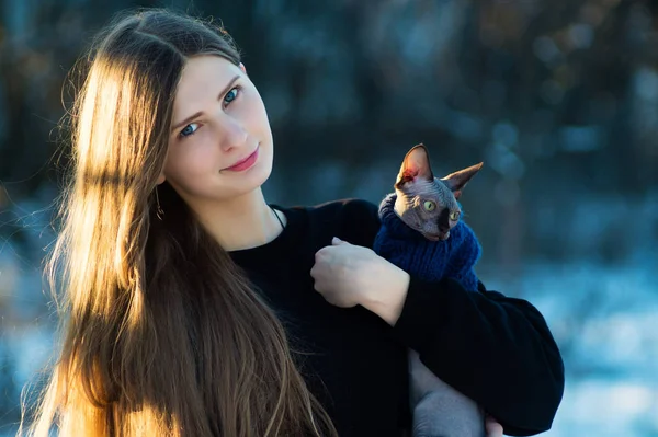 Молода красива дівчина з кицькою на руках. У зимовому парку у світлий день. Порода котів — стокове фото