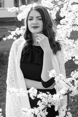 Güzel genç kız parkta bahar. Beyaz renk çemberi. siyah elbise siyah-beyaz portre.