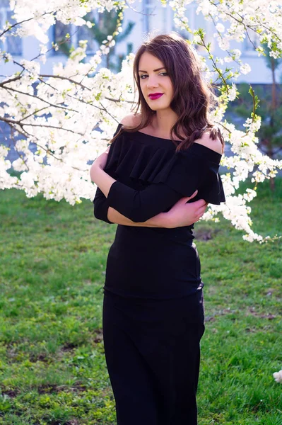 Modna Czarna Sukienka Dla Kobiety Wiosna Tle Białych Kwiatów — Zdjęcie stockowe