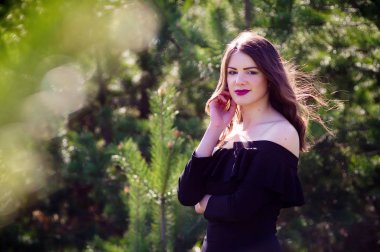 siyah elbise modeli. Sıcak güneşli parkta. güzel portre el yuvarlaktır.