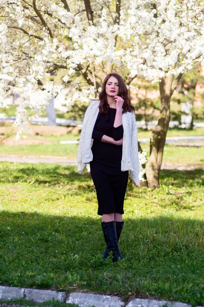 İlkbaharda parkta güzel bir genç kız. Tam yükseklikte portre. dikey resim