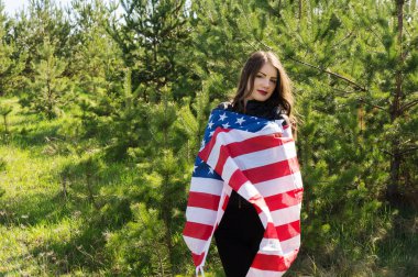 Bir bayrak Amerika Birleşik Devletleri sarılı bir bayrağı olan güzel bir kadın