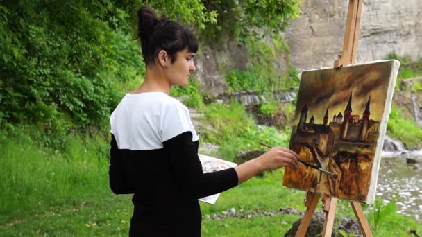 Malíř maluje obraz pevnosti. — Stock video