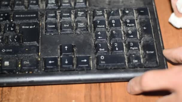 Limpando poeira de um teclado preto com um pano branco . — Vídeo de Stock