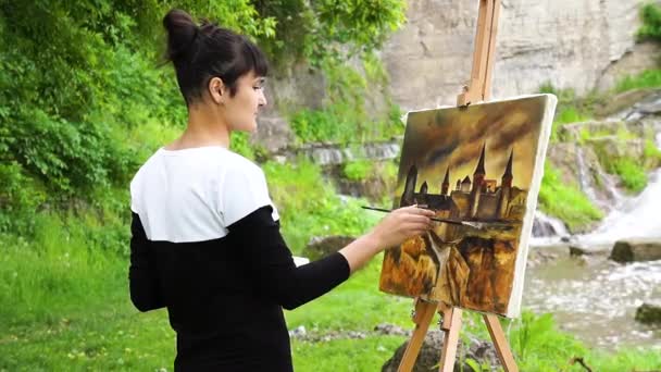 Målaren målar en bild av fästningen. — Stockvideo