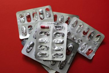 Kırmızı arka planda ilaçlar. Hastalıkların tedavisi.