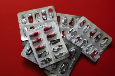 Kırmızı arka planda ilaçlar. Hastalıkların tedavisi.