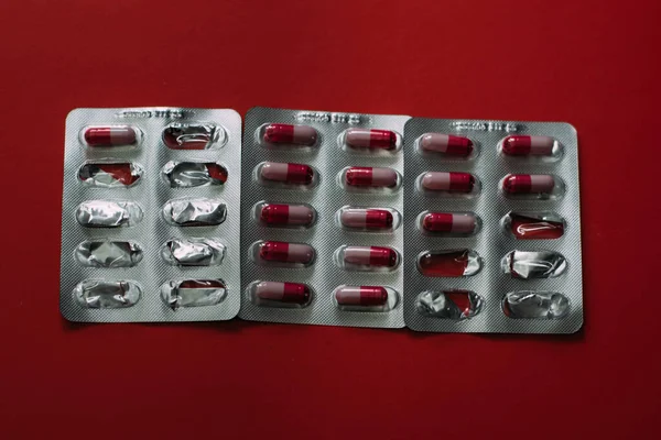 Médicaments sur fond rouge. Traitement des maladies . — Photo