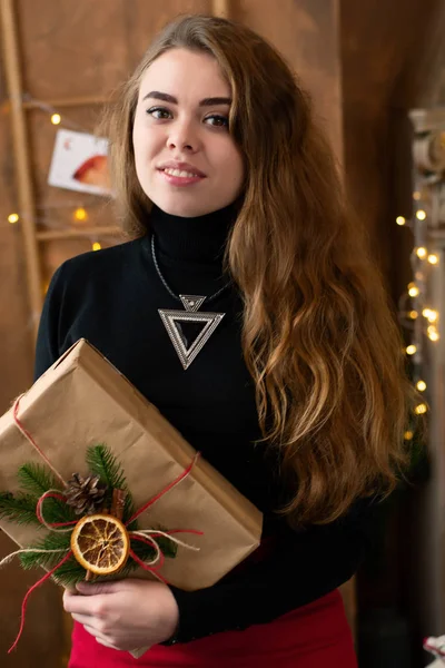 Charmantes Mädchen mit einem Weihnachtsgeschenk in der Hand. — Stockfoto