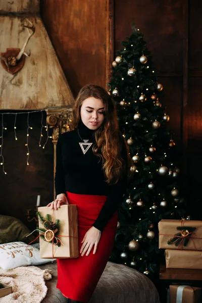 Charmantes Mädchen mit einem Weihnachtsgeschenk in der Hand. — Stockfoto