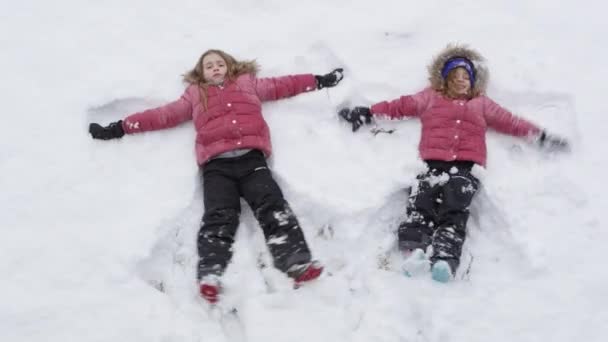 Młode Dziewczęta Robiące Śnieżne Anioły Oglądane Góry — Wideo stockowe
