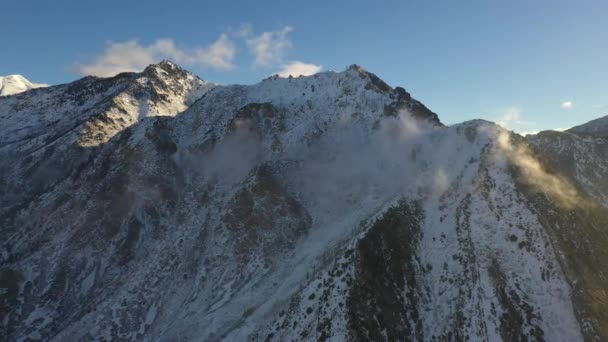 ユタ州の冬の間に薄雲が転がり落ちる雪に覆われた山頂 — ストック動画