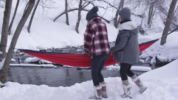 Twee Jonge Vrouw Zitten Hangmat Buiten Sneeuw Als Comfortabel Naast — Stockvideo