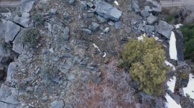 Uçurumun kenarındaki kamp yerine bakan bir hava manzarası. Aşağıdaki yerden yükseklerde oturan bir çiftin üzerinden uçuyor..