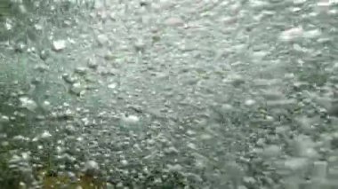 Nehirden akan kabarcıkların sualtı görüntüsü.