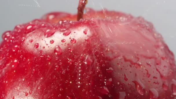 Agua Que Rocía Sobre Manzana Roja Medida Que Gira Lentamente — Vídeo de stock
