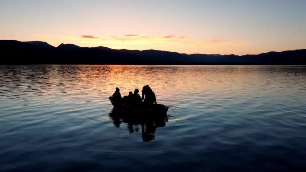カラフルな日没の間にヘブン湖に浮かぶボートの始動運動を引く人 — ストック動画