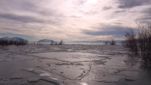 表面に砕けた氷で凍結した湖を飛び越えてテクスチャと広いオープンスカイを表示します — ストック動画