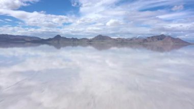 Suyun altında Bonneville Tuz Düzlükleri üzerinde hızla uçarken gökyüzü suyun yüzeyine yansıyor..