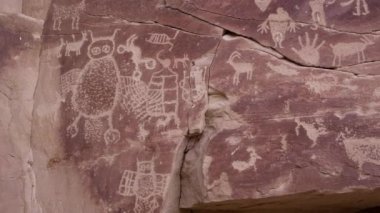 Utah Nine Mile Kanyonu 'ndaki eski Amerikan yerlilerinin kaya, insan ve el izleriyle birlikte büyük baykuş oymalı petroglyph panel manzarası..