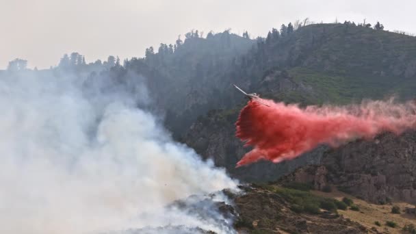 Avion larguant un ignifuge sur un feu de forêt brûlant sur une montagne au-dessus de Provo Utah le 31 juillet 2019 .
