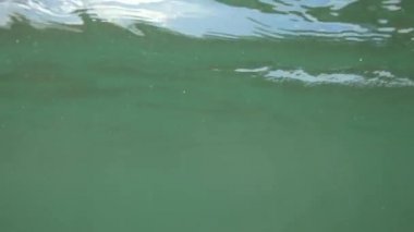 Dalgalar okyanusta yuvarlanırken suyun üstünde ve altında bak.
