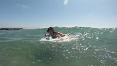 Genç adam dalgaların önüne atlarken kıyıya doğru süzülüyor..