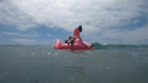 一个年轻的女人骑在浮筒上的波浪冲向相机时 — 图库视频影像