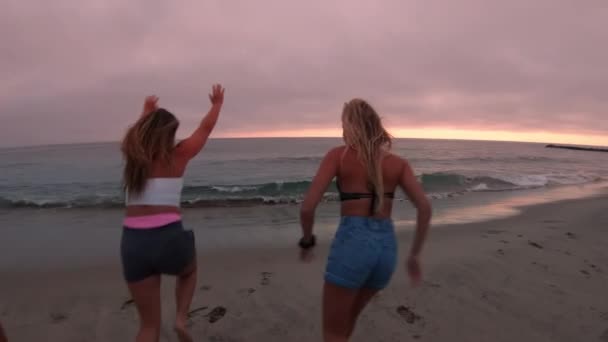 Три Молодые Женщины Бегут Океану Прыгают Колесо Песке Время Заката — стоковое видео