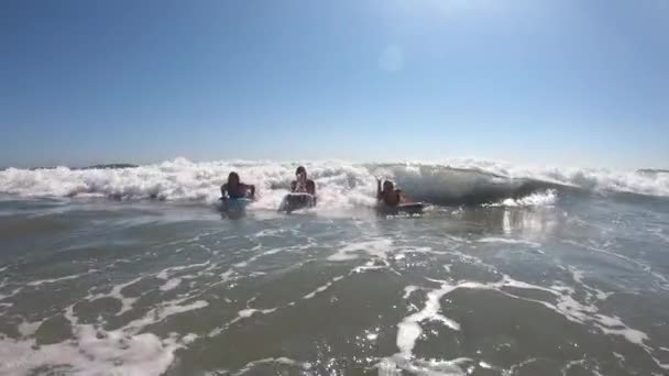 年轻女性一边在海里享受着欢乐和欢笑 一边在摇摆板上挥挥手 — 图库视频影像