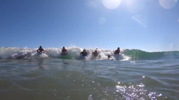 Groupe d'amis et de la famille chevauchant une vague ensemble sur des planches de boogie à la plage en vacances en Californie .