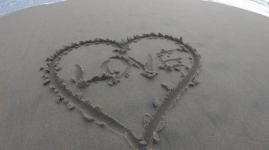 Kumsalda bir kalple kumlara yazılmış bir aşk..