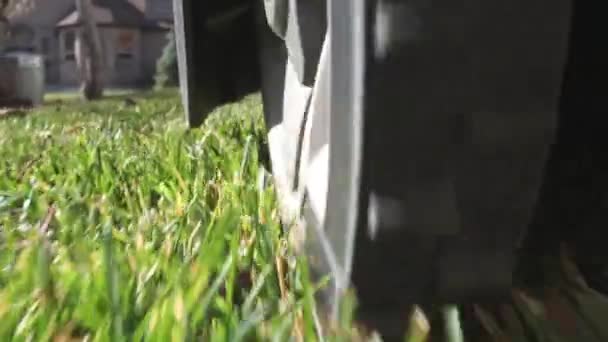 地上の車輪の後ろから草を刈るときのロボット芝刈り機に続く — ストック動画