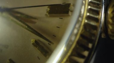 Altın saatin yakın görüntüsünde ikinci el bir saat geçtikçe....