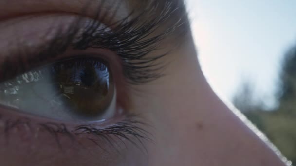 Zbliżenie Widok Kobiecego Oka Mrugającego Kierunku Słońca — Wideo stockowe