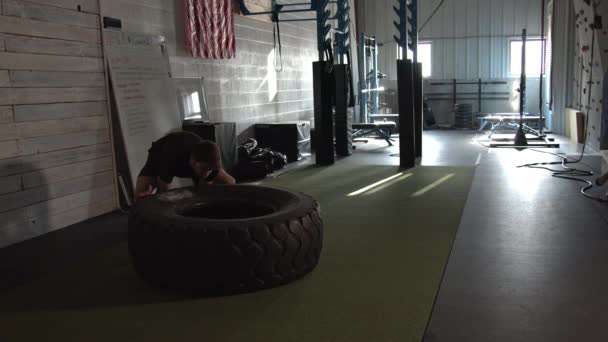 Homem Levantando Lançando Sobre Pneu Gigante Ginásio Como Ele Exercita — Vídeo de Stock