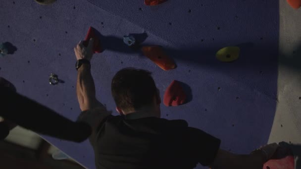 体操のためにジムで壁に登る男は彼を下に発見しながら — ストック動画