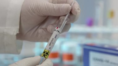 Svid-19 'un tüpte ve tıbbi laboratuarda plastik torbada mühürlenmesini yakından izle..