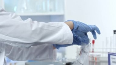 Tıbbi tesiste çalışan kadın laboratuvar teknisyeni CV19 test kitleri üzerinde çalışıyor..