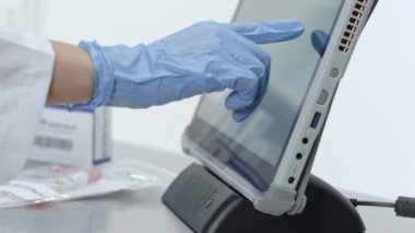 Laboratuvar teknisyeni Coronavirus salgını sırasında dokunmatik ekran covid-19 test kitleri kullanıyor..