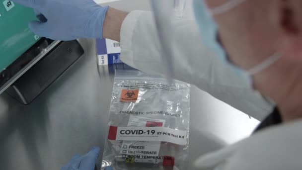 在实验室使用触摸屏计算机制作Covid 19工具箱的医务人员的肩膀以上的表情 — 图库视频影像