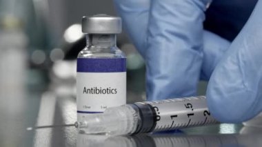 Tıbbi laboratuarda yanında şırınga bulunan antibiyotik şişesi..