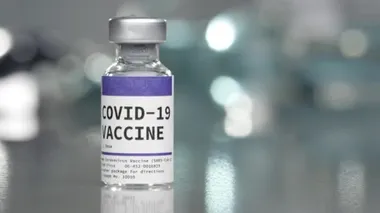 Covid-19 Coronavirus aşı şişesi tıbbi laboratuvarda şırıngayla yavaşça yerleştirilirken....