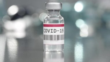 Coronavirus Covid-19 aşı şişesi tıbbi laboratuvarda yavaşça dönüyor..