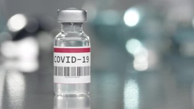 Coronavirus Covid-19 aşı şişesi tıp laboratuarında, yanında şırınga ile birlikte..