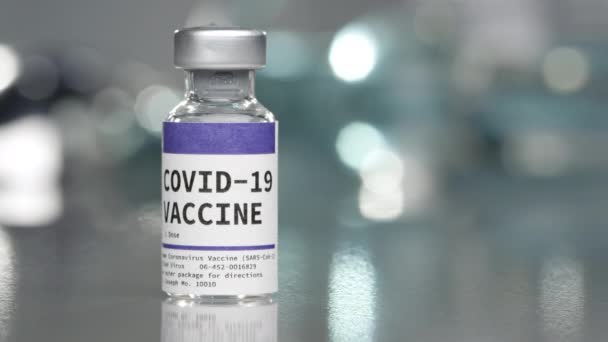 Covid 19ゆっくりと回転しながら注射器を次に置く医療ラボでのコロナウイルスワクチン — ストック動画