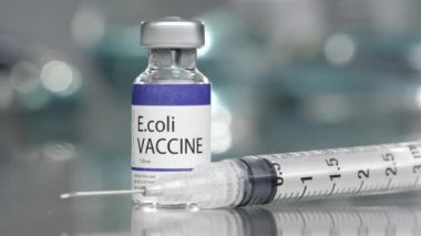 Ekoli aşısı şişesi orta laboratuvarda, yanındaki şırınga yeri yavaşça dönüyor..