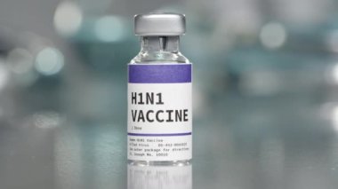 Tıp laboratuarında H1N1 aşı şişesi yavaşça dönüyor.