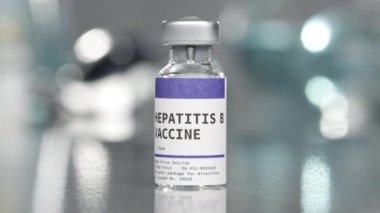 Tıp laboratuarında hepatit B aşısı şişesi yavaşça dönüyor..