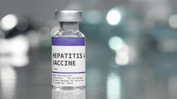 肝炎それの隣に置かれた注射器を備えた医療研究室のワクチン瓶 — ストック動画